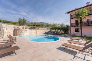 a swimming pool with benches and a building at Residence La Vigna in Arco +22 photos