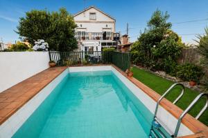 a swimming pool in front of a house at Casa Maruja O Grove in O Grove