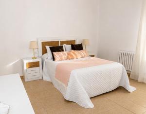 a white bedroom with a large bed with pink pillows at Casa Maruja O Grove in O Grove +22 photos