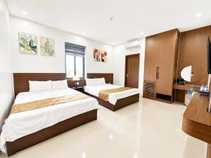 a bedroom with two beds and a bathroom at TRƯỜNG THỊNH Hotel in Hòn Tru