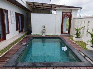 a swimming pool in the backyard of a house at Villa Gema Laut in Tabanan