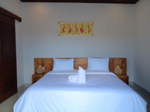 a white bed with two towels on top of it at Villa Gema Laut in Tabanan