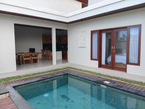 a villa with a swimming pool and a bedroom at Villa Gema Laut in Tabanan