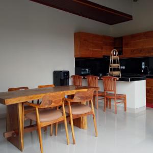 a dining room with a wooden table and chairs at Villa Gema Laut in Tabanan