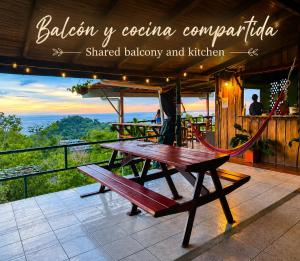 a picnic table and a hammock on the deck of a building at Pura Natura Lodge in Manuel Antonio