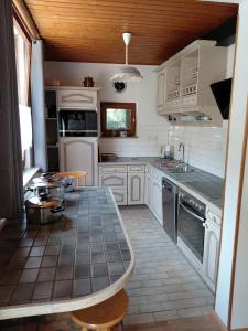a kitchen with white cabinets and a tile floor at Rurterasse in Monschau