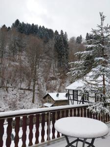 a snow covered balcony with a bench and a house at Rurterasse in Monschau