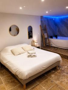 a bedroom with a bed and a tub in a room at Suite avec jacuzzi DOLCE NOTTE in Rochegude