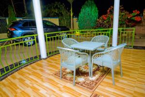 a table and chairs on a porch with a car at KEFA Town Hotel in Kigali