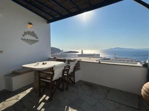 a balcony with a table and chairs looking out at the ocean at Above the Blue in Agios Sostis
