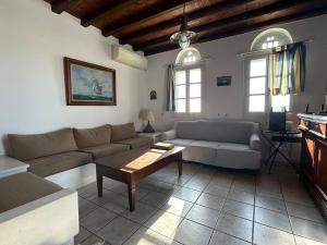 a living room with a couch and a table at Above the Blue in Agios Sostis