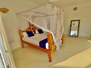 a bedroom with a canopy bed and a mirror at Deluxe room in Watamu