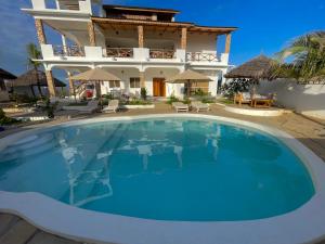 a large swimming pool in front of a house at Deluxe room in Watamu +11 photos