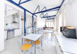 a kitchen with white tables and chairs and blue beams at Nest Style Granada in Granada