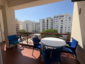 a balcony with a table and chairs and a view of a city at Edificio Caique C in Armação de Pêra