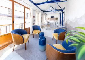 a waiting room with blue chairs and a table at Nest Style Granada in Granada