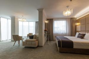 a hotel room with a bed and a chair at Centralis Hotel in Haskovo
