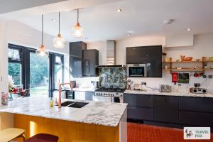 a kitchen with black cabinets and a counter top at Springfield House in Cheadle
