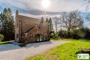 an old brick building with the sun in the sky at Springfield House in Cheadle