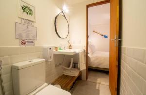 a bathroom with a toilet and a sink and a mirror at Bella Buzios Apartamentos in Búzios +53 photos