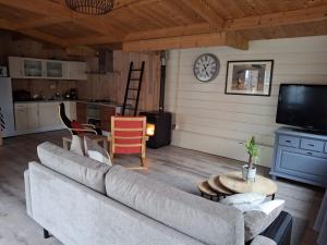 a living room with a couch and a clock on the wall at Guesthouse Bij Maud in Barsingerhorn +10 photos