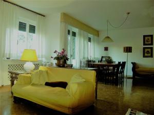 a living room with a yellow couch and a table at Villa vista Fiesole in Florence