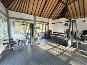 ein Fitnessstudio mit mehreren Laufbändern und Geräten in einem Raum in der Unterkunft The Hamsa Bali Resort in Lovina