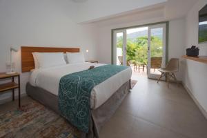 a bedroom with a bed and a sliding glass door at Pouso Alforria in Tiradentes