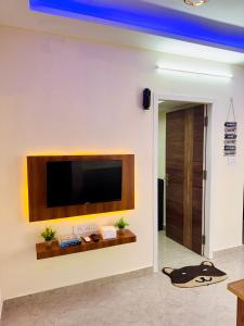a living room with a flat screen tv on a wall at Namma Suites cozy 1BHK Stay Near Koramangala BTM layout in Bangalore +7 photos