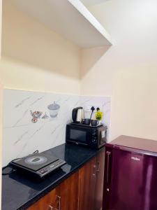 a kitchen with a microwave on top of a counter at Namma Suites cozy 1BHK Stay Near Koramangala BTM layout in Bangalore