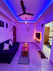 a purple living room with a couch and a table at Namma Suites cozy 1BHK Stay Near Koramangala BTM layout in Bangalore