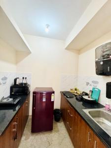 a kitchen with a sink and a refrigerator in it at Namma Suites cozy 1BHK Stay Near Koramangala BTM layout in Bangalore