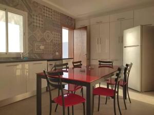 a kitchen with a table with chairs and a refrigerator at Dar saber in Sfax