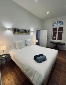 a bedroom with a large white bed with a towel on it at Les gîtes in Daubeuf-Serville