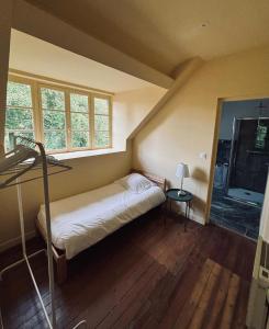 a small bedroom with a bed and a window at Les gîtes in Daubeuf-Serville