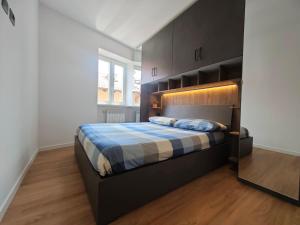 a bedroom with a bed with a blue and white blanket at Trilo Orologio in Clusone +10 photos