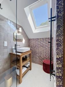 a bathroom with a sink and a skylight at Chambre d'hôtes Cocotte & Bigoudi in La Ferté-Beauharnais