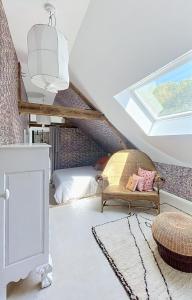 a attic room with a chair and a bed at Chambre d'hôtes Cocotte & Bigoudi in La Ferté-Beauharnais +22 photos