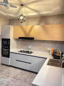 a kitchen with white counters and a stove top oven at Modern Three-Bedroom Apartment in Accra