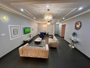 a large living room with couches and a tv at Modern Three-Bedroom Apartment in Accra