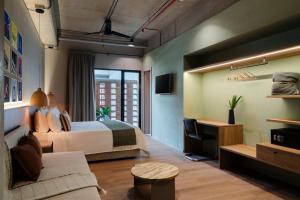 a hotel room with a bed and a desk at Obra Hotels in Medellín