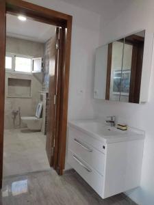 a bathroom with a sink and a toilet and a mirror at Dar saber in Sfax