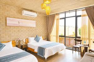 a hotel room with two beds and a balcony at Tình's Homestay in Ninh Binh