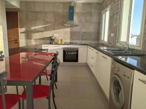 a kitchen with a table and a washing machine at Dar saber in Sfax +4 photos