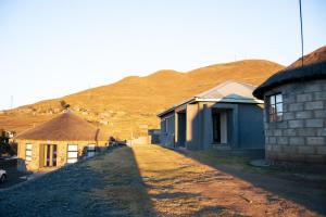 a group of buildings with a mountain in the background at Dam View Guest house in Bokong