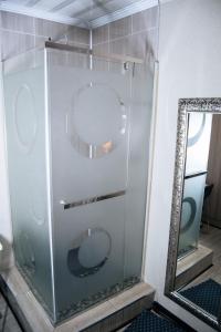 a glass shower in a bathroom with a mirror at Dam View Guest house in Bokong +16 photos