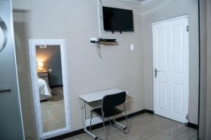 a room with a mirror and a table and a desk at Dam View Guest house in Bokong