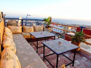 a balcony with two tables and a couch at Paradise House Apartment in Tamraght in Tamraght Ouzdar