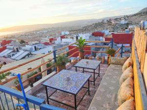 a balcony with tables and a view of the city at Paradise House Apartment in Tamraght in Tamraght Ouzdar