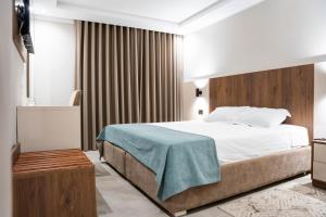 a bedroom with a bed with a blue blanket on it at Hôtel Passage in Tunis